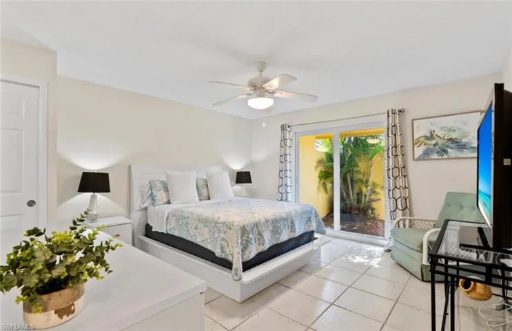 Bedroom featuring sliding glass doors opening to a private outdoor space with lush foliage