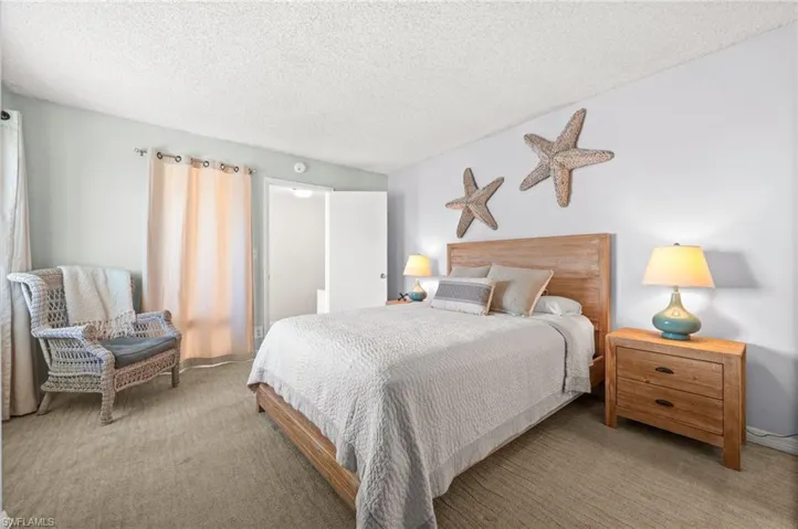 Bedroom with a textured ceiling and carpet flooring