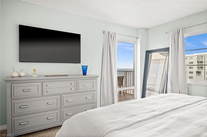 Bedroom with access to outside, a textured ceiling, and light wood-style floors