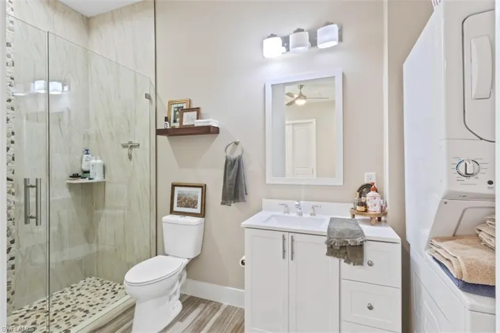 Glass-enclosed shower with pebble-tile floor and vertical stone accent