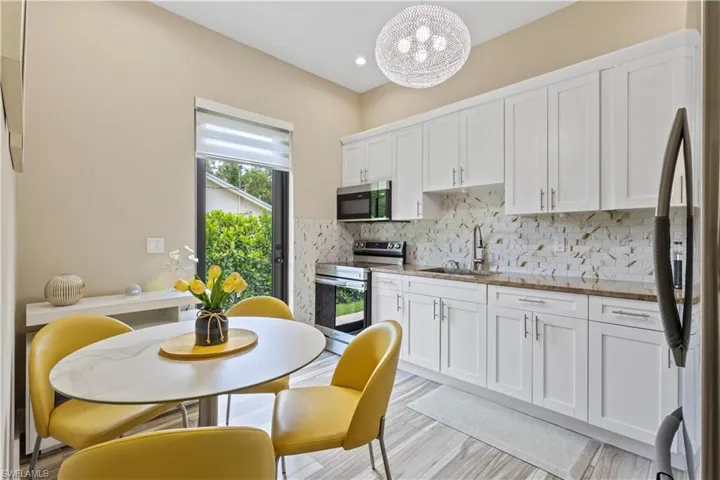 Kitchen featuring white shaker cabinetry, stainless steel appliances, and stone countertops