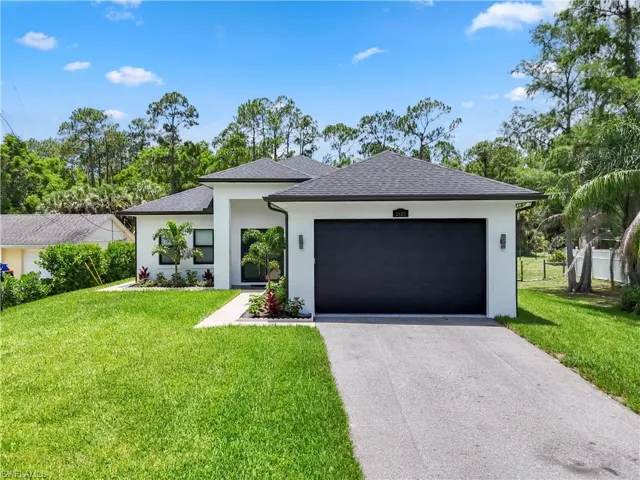 Modern stucco exterior with black-framed windows, a dark garage door, and a light gray shingle roof