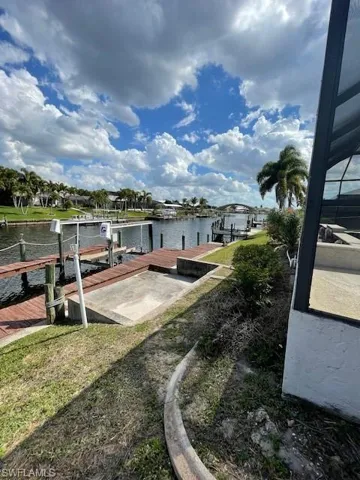 Dock featuring a lanai, boat lift, and a water view