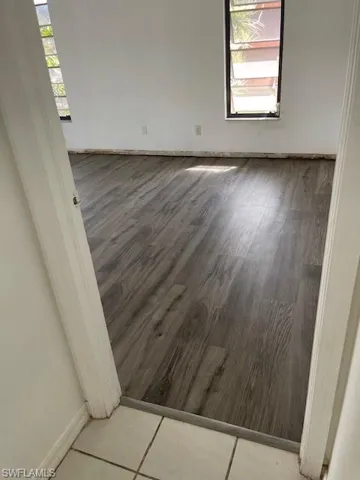 Unfurnished room featuring a ceiling fan, light tile patterned floors, lofted ceiling, and a skylight