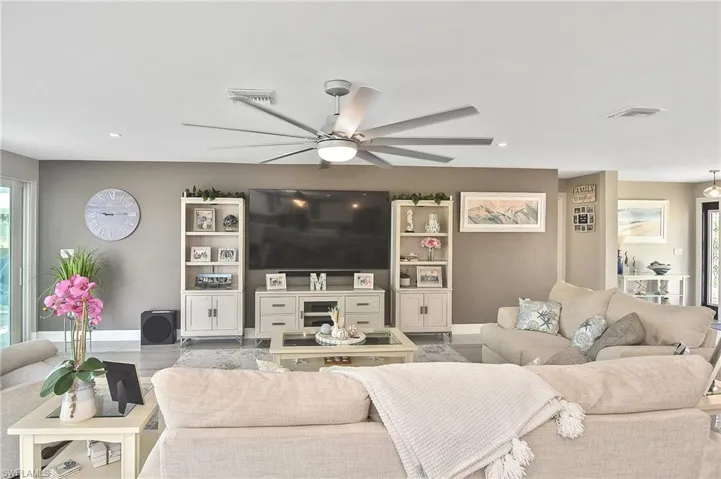 Living room featuring baseboards, ceiling fan, visible vents, and wood finished floors