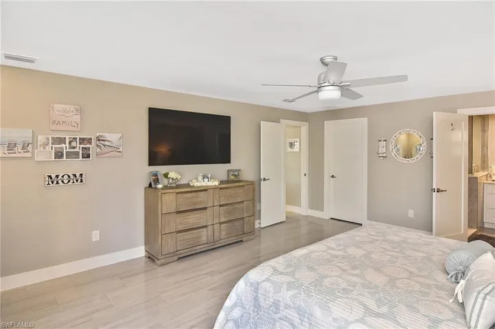 Bedroom with baseboards, a ceiling fan, visible vents, and light wood-type flooring