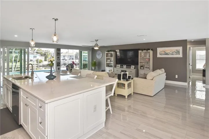Kitchen featuring white cabinets, a sink, plenty of natural light, and ceiling fan