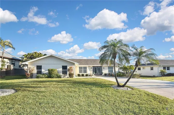 Single story home featuring a front yard and concrete driveway
