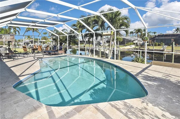 View of pool with a water view, a lanai, a patio, boat lift, and a boat dock