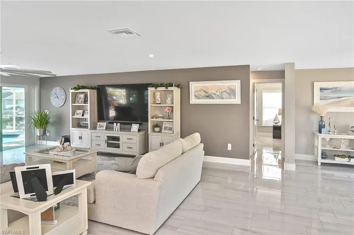 Living area with a ceiling fan, baseboards, and visible vents