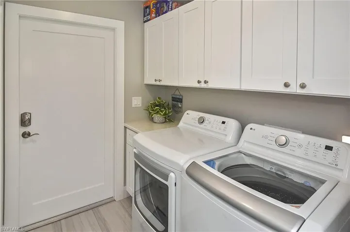 Washroom with washing machine and clothes dryer and cabinet space