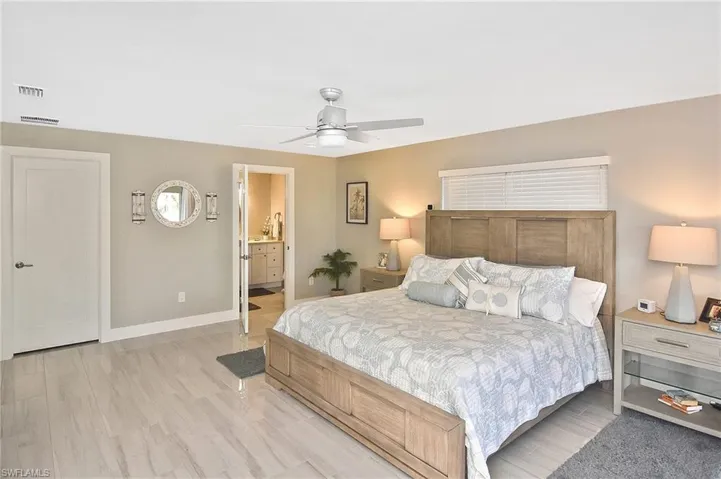 Bedroom with baseboards, visible vents, light wood-type flooring, and a ceiling fan