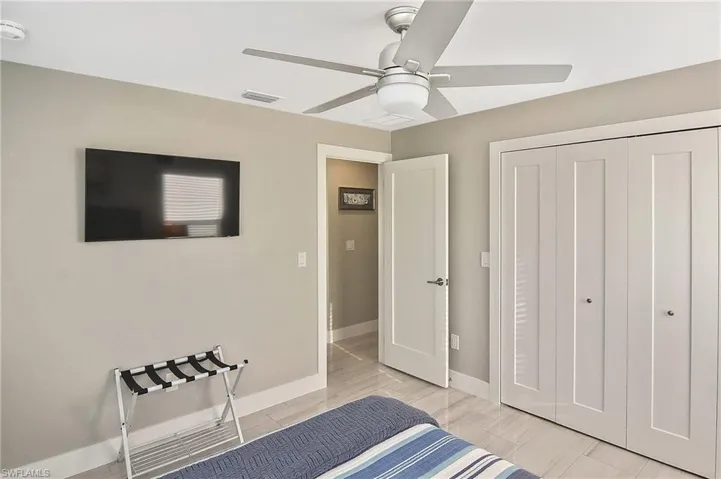 Unfurnished bedroom featuring a closet, visible vents, baseboards, wood finish floors, and a ceiling fan