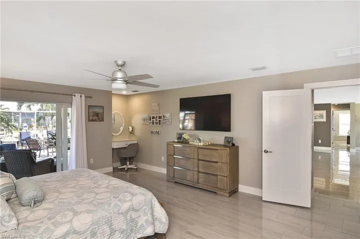 Bedroom featuring baseboards, access to exterior, visible vents, and ceiling fan
