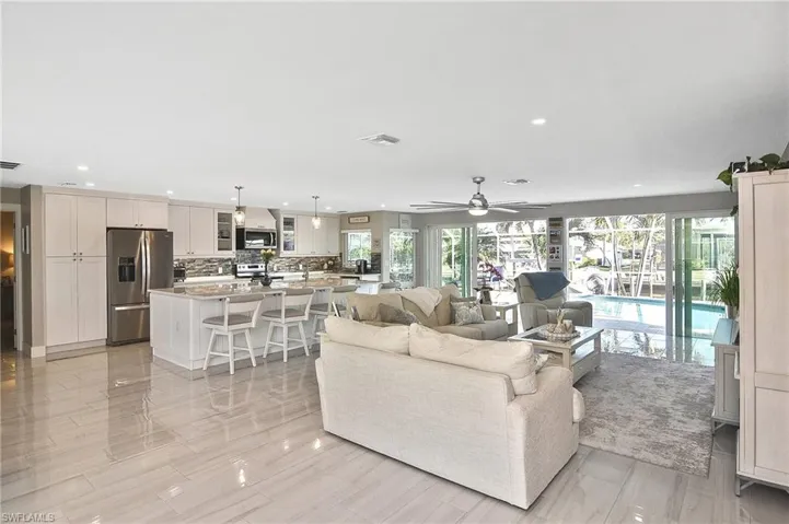 Living area with visible vents, ceiling fan, and a healthy amount of sunlight