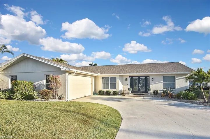 Single story home featuring a front yard, stucco siding, an attached garage, and concrete driveway
