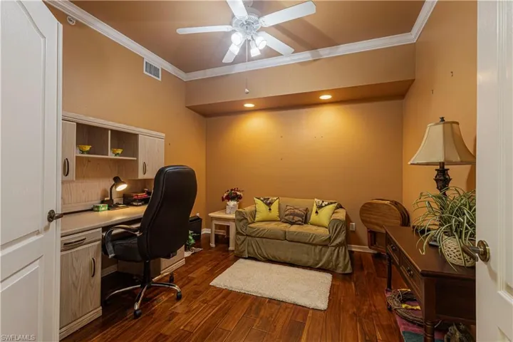 Flex room with ceiling fan (den, playroom, home office, media center)Flex room with ceiling fan, dark hardwood / wood-style flooring, and ornamental molding