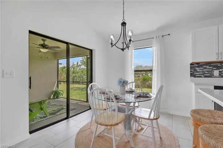 Dining area featuring hanging lights, ceiling fan, and light tile patterned flooring