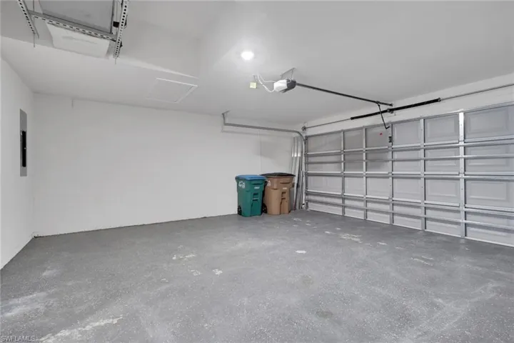 Garage featuring electric panel and a garage door opener