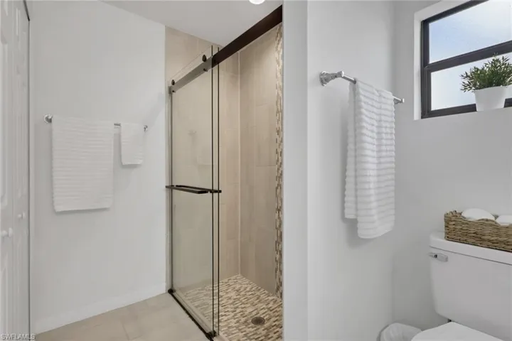 Full bathroom featuring a walk-in shower, toilet and a full 3rd closet
