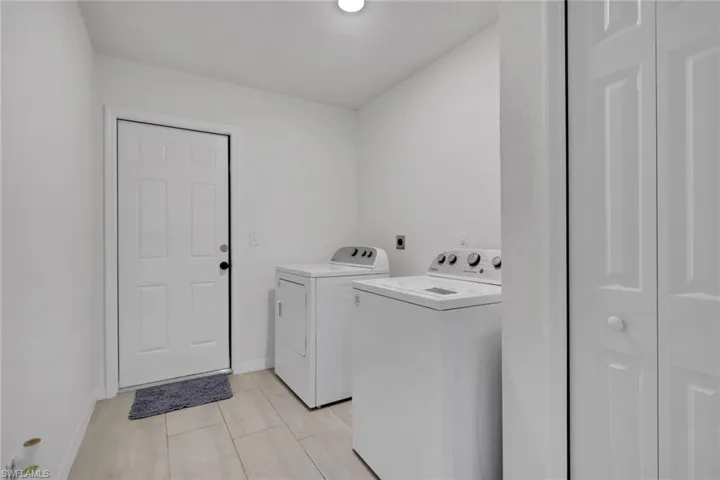 Laundry area with additional storage closet and washing machine and dryer