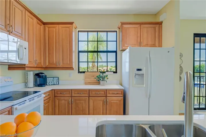 Kitchen featuring white appliances and brown cabinetry