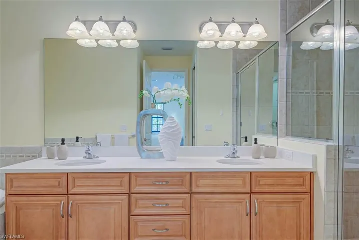 Full bath featuring a stall shower and double vanity