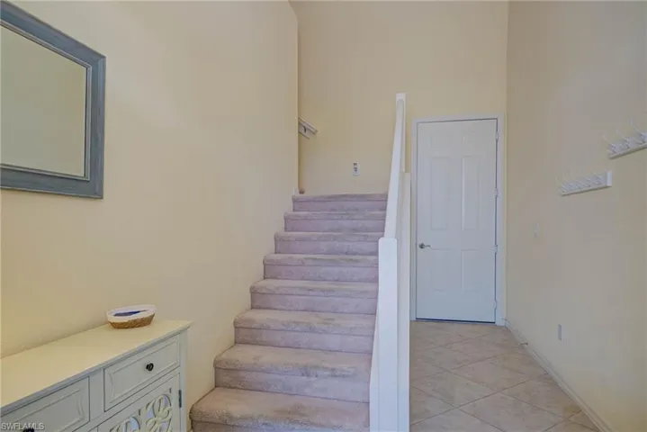 Staircase with tile patterned flooring and baseboards