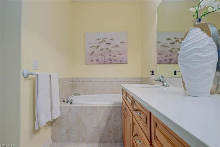Full bath with a bath, vanity, and light tile patterned floors