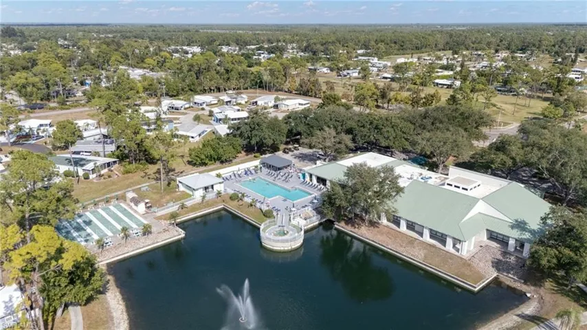 Drone / aerial view of a nearby body of water and a pool area