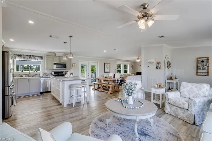 Living area featuring healthy amount of natural light, recessed lighting, light wood finished floors, crown molding, and ceiling fan