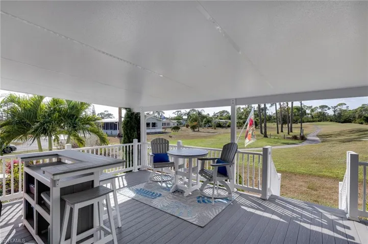 Wooden terrace with a lawn and outdoor dining area