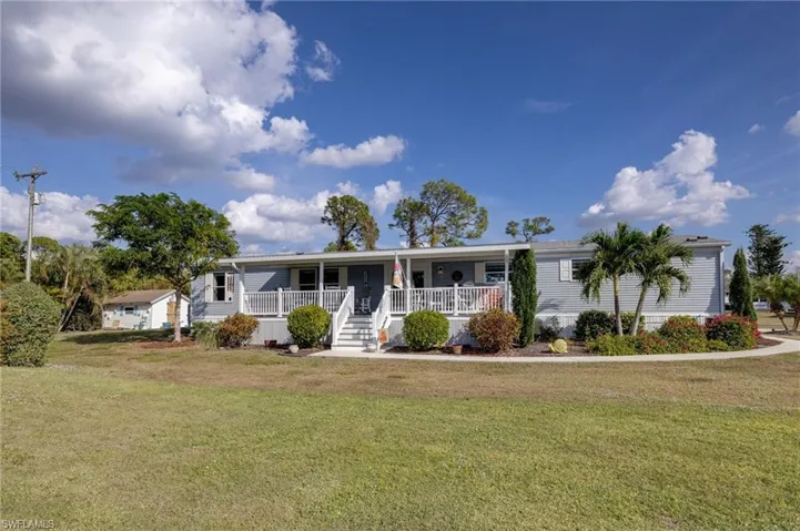 View of front of property with covered porch and a front yard