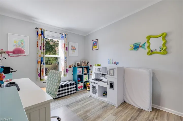 Office featuring light wood-style flooring and crown molding
