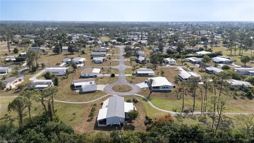 Aerial view of property and surrounding area featuring nearby suburban area