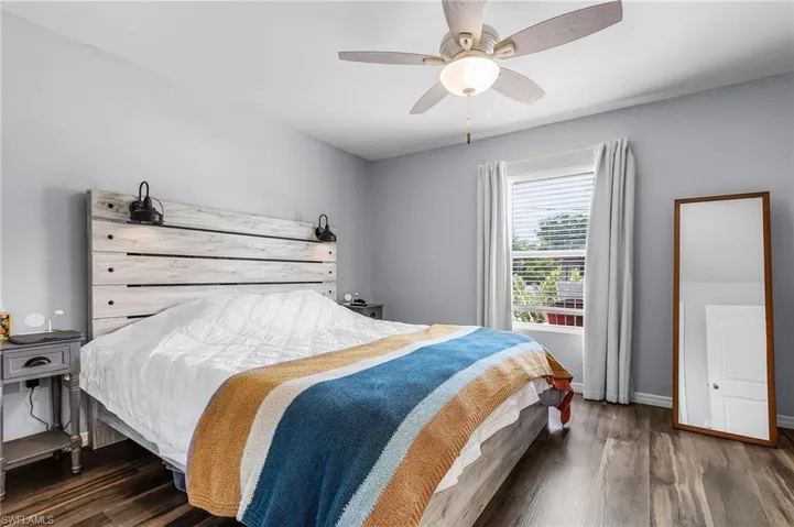 Bedroom with dark wood-style flooring and a ceiling fan