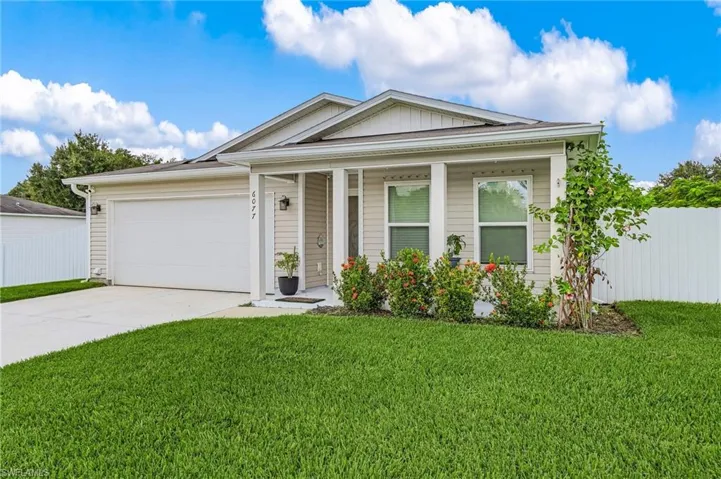 Ranch-style home featuring a porch, driveway, board and batten siding, and a garage