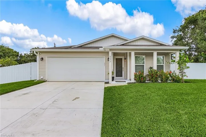 Ranch-style home with a porch, concrete driveway, a garage, and board and batten siding
