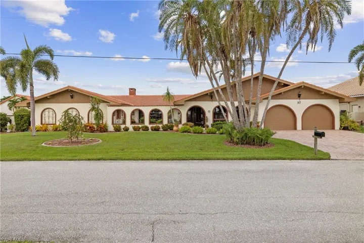 Mediterranean / spanish house featuring a garage and a front yard
