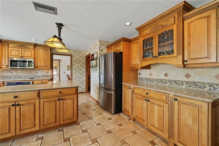 Kitchen featuring appliances with stainless steel finishes, a textured ceiling, and pendant lighting
