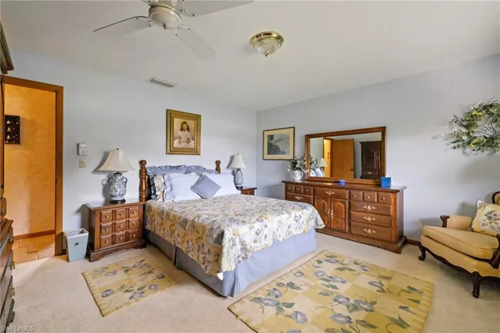 Bedroom with light colored carpet and ceiling fan