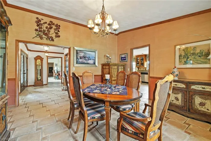 Dining area with crown molding and a chandelier