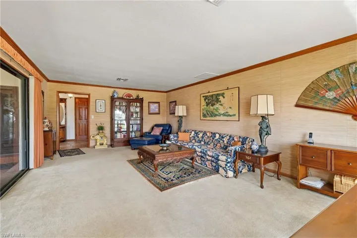 Carpeted living room with crown molding