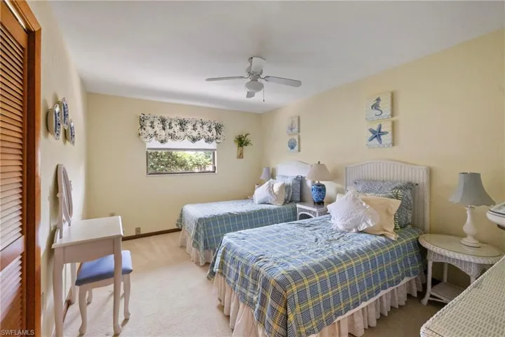 Carpeted bedroom featuring ceiling fan