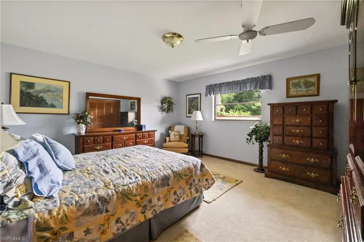Carpeted bedroom featuring ceiling fan