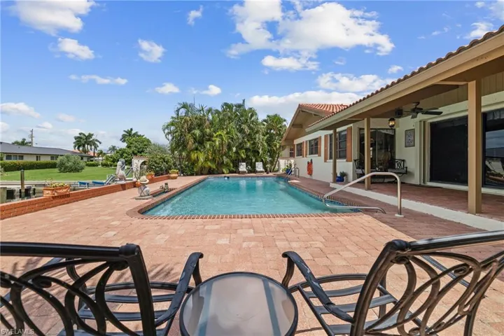 View of swimming pool with ceiling fan and a patio