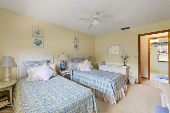 Carpeted bedroom featuring ceiling fan