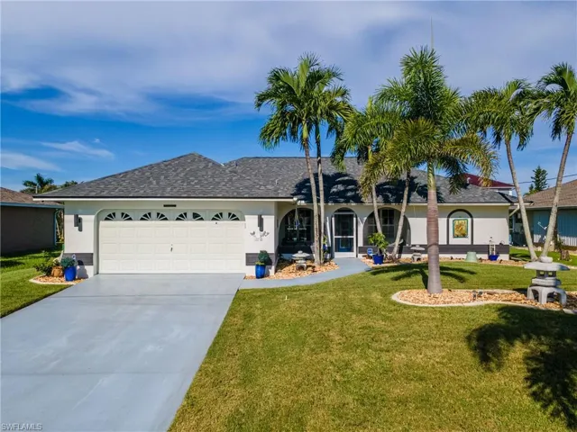 Single story home with stucco siding, driveway, a garage, and a front lawn