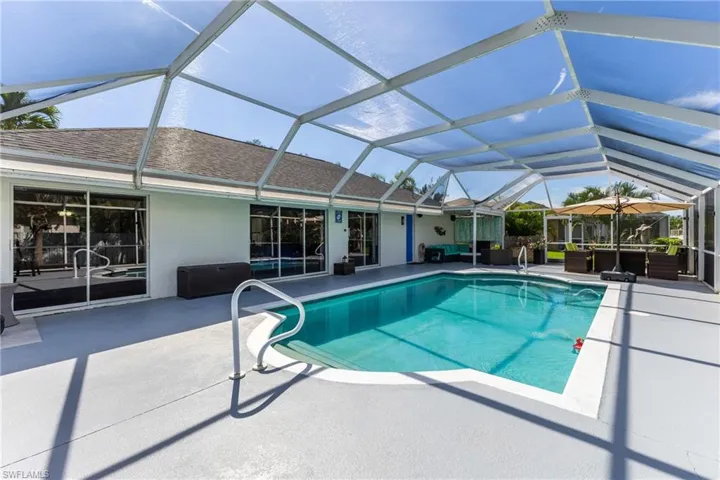 Swimming pool featuring a sunroom, glass enclosure, a patio, and outdoor lounge area