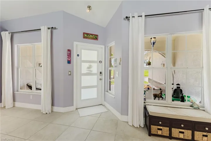 Foyer entrance featuring lofted ceiling and light tile patterned floors